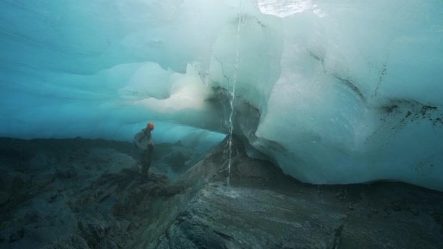 Slow Motion/Pan Up: Water Pouring Through Hole In Large Glacier - Mendenhall Glacier, Alaska