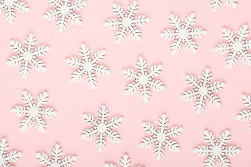 Christmas background. White snow decorations on a pink background.