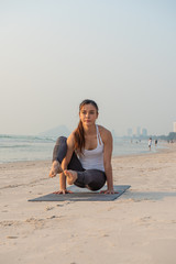 Fototapeta na wymiar Yoga woman doing yoga pose on the beach at sunrise.