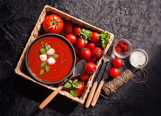 Summer cold tomato vegetable soup Gazpacho on the black table. Vegetarian cuisine. The view from the top. The concept of healthy eating.