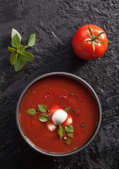 Summer cold tomato vegetable soup Gazpacho on the black table. Vegetarian cuisine. The view from the top. Copy space. The concept of healthy eating.