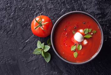 Summer cold tomato vegetable soup Gazpacho on the black table. Vegetarian cuisine. The view from...