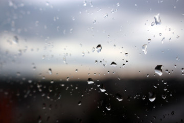 Big rain drops on clear window glass