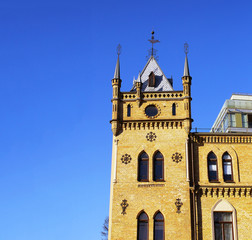 Fototapeta na wymiar Old gothic castle tower top on blue sky background