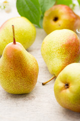 Fresh pears with leaves in a on wooden background.