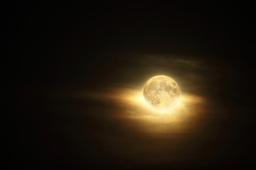 Detailed full moon in dark cloudy sky