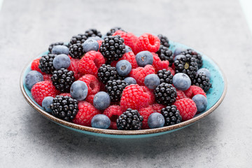 Fresh raspberries in a plate on a  vintage background.