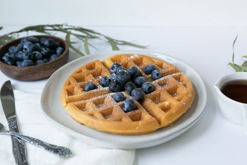 Belgian Waffle with Blueberries and Maple Syrup, Dusted with Powdered Sugar, Flay Lay on White Background, Copy Space