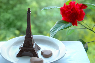 Chocolate dessert on a plate the eiffel tower and two hearts. Outdoors.