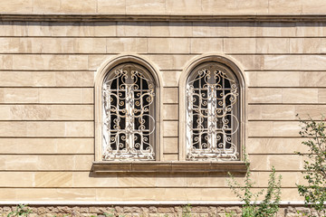 Rusticated stone wall with two arched Windows