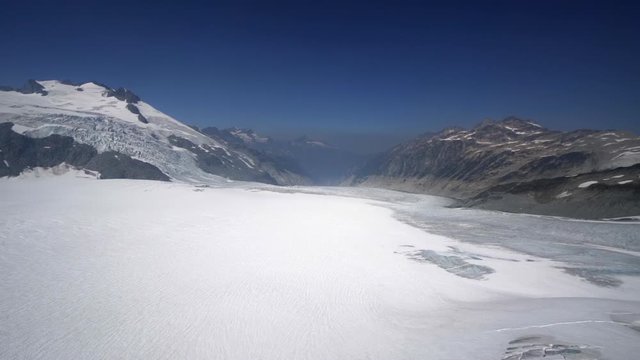 Aerial Right: Snowy Valley Surrounded By Mountains, Foggy, Blue Sky Above - Mendenhall Glacier, Alaska