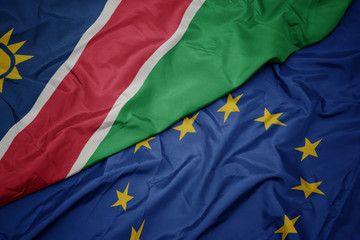 waving colorful flag of european union and flag of namibia.
