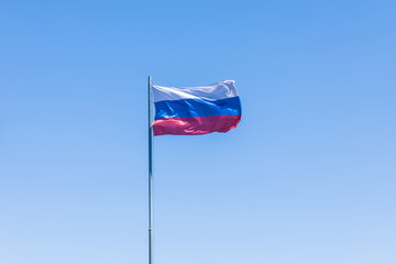 The government flag of Russia or Russian Federation on the sky background