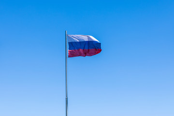 The government flag of Russia or Russian Federation on the sky background