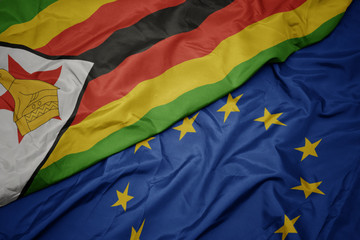 waving colorful flag of european union and flag of zimbabwe.