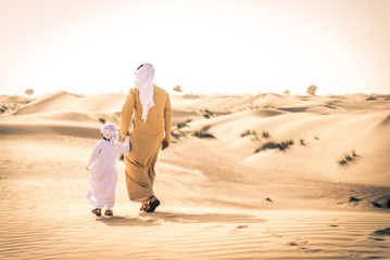 Arabian man and son playing in the desert