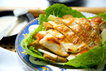 Chicken dish from a restaurant. Cesar Salad.