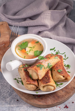 Minced meat rolled crepes served with broth. Russian cuisine