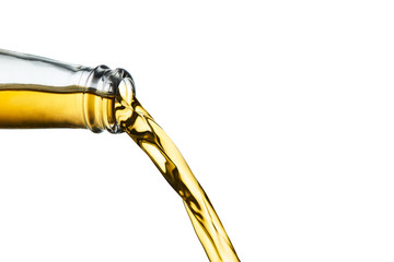 Closeup of golden ale pouring from clear bottle isolated on white background.