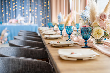 luxury dinner Banquet in the restaurant. Beautiful and exquisite decoration of the wedding celebration. Banquet served table with a beige pink tablecloth, plates and candlesticks with candles.