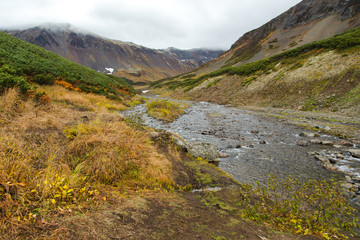 Beautiful waterfall in mountains, scenic autumn landscape in Kamchatka