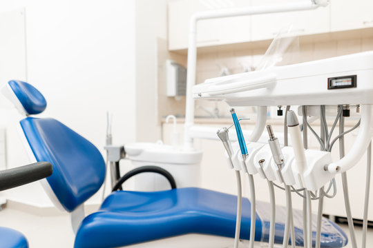 Close-up dentist armchair. Dental work in clinic. Operation, tooth replacement. Medicine, health, stomatology concept. Office where dentist conducts inspection and concludes.