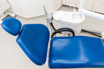 Close-up dentist armchair. Dental work in clinic. Operation, tooth replacement. Medicine, health, stomatology concept. Office where dentist conducts inspection and concludes.