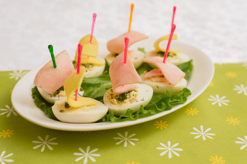 Children's food in the form of ships. Creative sandwiches of eggs in the form of ships. Children's menu on a green background.