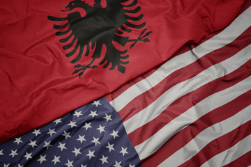 waving colorful flag of united states of america and national flag of albania.