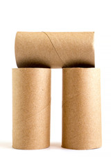 Composition from three cardboard paper tubes on white background. Close-up of empty toilet rolls