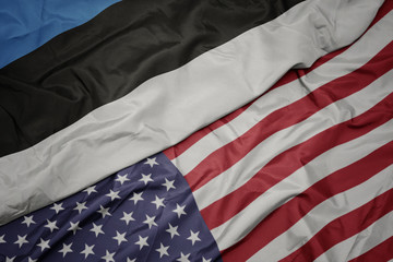 waving colorful flag of united states of america and national flag of estonia.