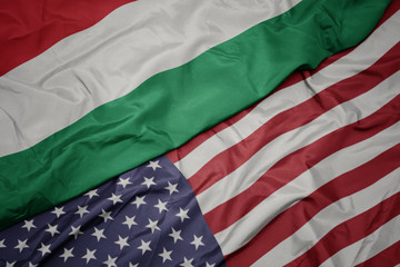 waving colorful flag of united states of america and national flag of hungary. macro