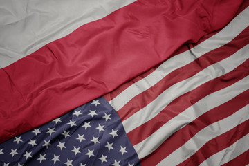 waving colorful flag of united states of america and national flag of poland. macro
