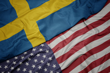 Fototapeta na wymiar waving colorful flag of united states of america and national flag of sweden. macro
