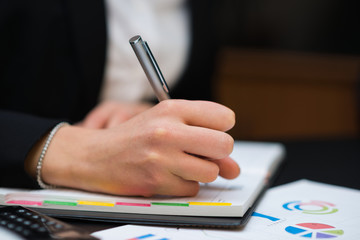 Detail of a woman writing on her agenda