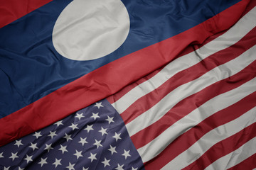 Obraz premium waving colorful flag of united states of america and national flag of laos.