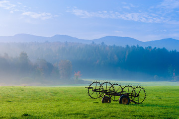 Antique farm machinery on a foggy autumn morning.