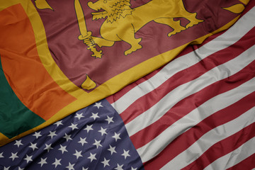 waving colorful flag of united states of america and national flag of sri lanka.