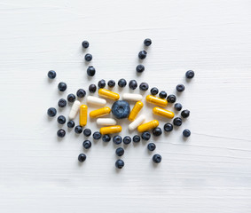 Conceptual photo of the treatment of vision. Products that improve vision. Blueberries and vitamins for eye health. View from above.