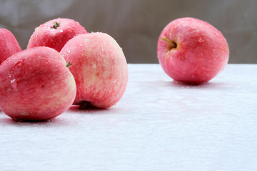 Red apples with water drops.Beautiful background. The concept of a rich harvest in the garden. Apples close-up on a white Board.Green background.