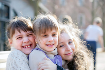 Fototapeta premium Three sisters sitting on bench in park.