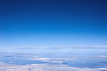 Naklejka na ściany i meble Blue sky above the clouds from airplane window