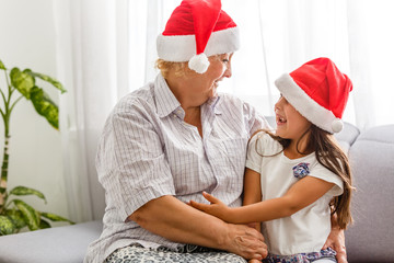 Grandmother with granddaughter in santa hat