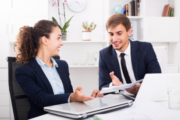 portrait of  business man and woman colleagues chatting about work in office