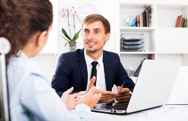 Business male assistant wearing formalwear using laptop