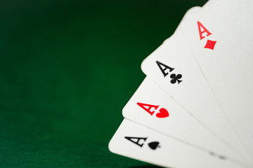Four aces on a green background.