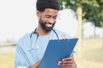 Beautiful happy doctor outside in the park
