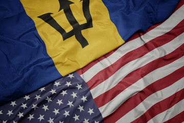Obraz premium waving colorful flag of united states of america and national flag of barbados.