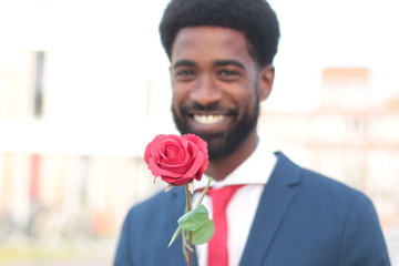 Beautiful happy man outside in the park with roses