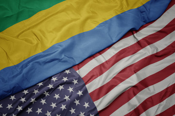 waving colorful flag of united states of america and national flag of gabon.